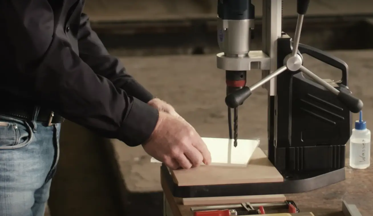 Support the plastic on a flat surface that you can drill into